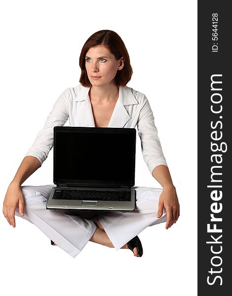 Businesswoman in white clothes sits near a laptop on a floor