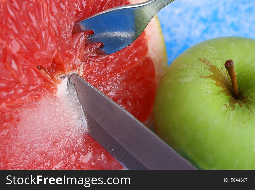 Sliced Pomelo with Sugar and a knife, fork and apple. Sliced Pomelo with Sugar and a knife, fork and apple