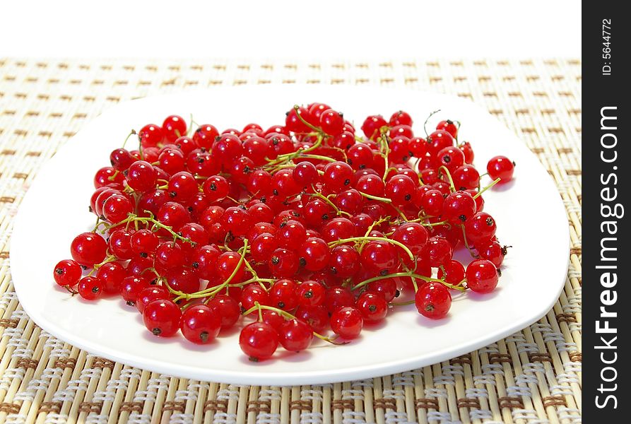 Red and black currant on a white plate. Red and black currant on a white plate