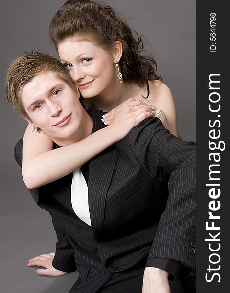 Portrait of a young beautiful couple on gray background