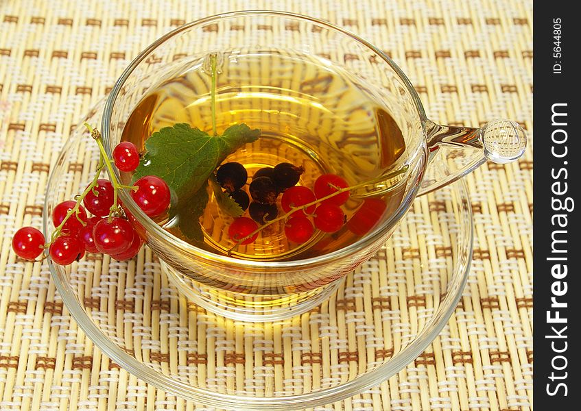 Red currant and tea in a transparent cup