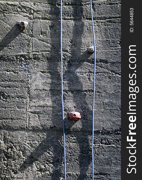 A climbing concrete wall with ropes. A climbing concrete wall with ropes