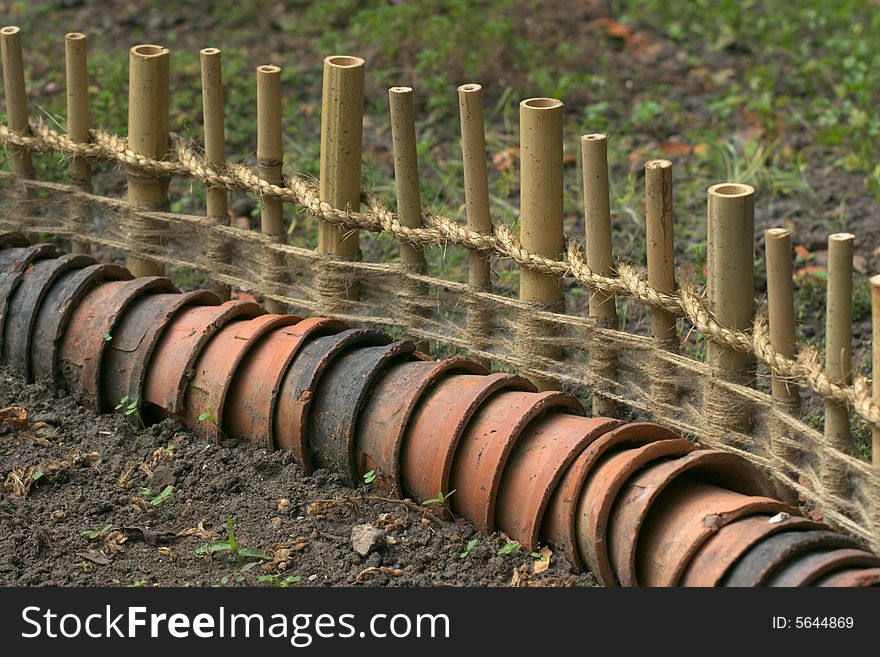 Garden fence of bamboo and earthen pots