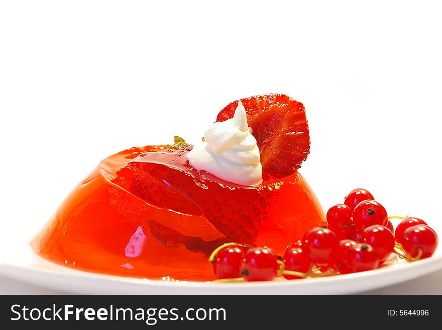Fruit jelly decorated by a currant and whipped cream. Fruit jelly decorated by a currant and whipped cream