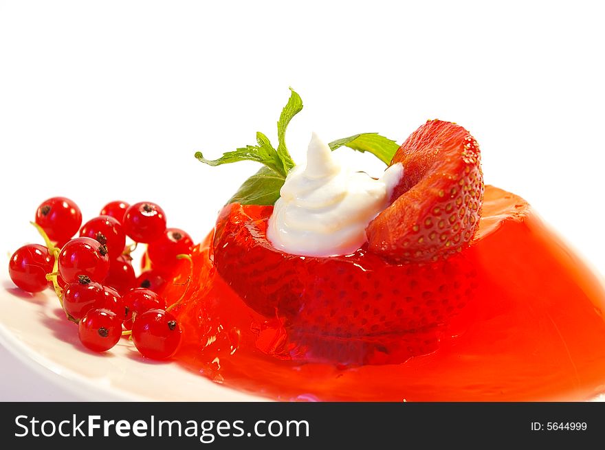 Fruit jelly decorated by a currant and whipped cream