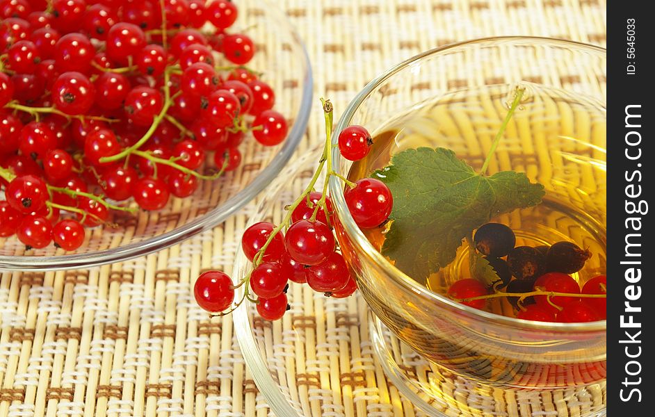 Red currant and herbal tea in a transparent cup. Red currant and herbal tea in a transparent cup