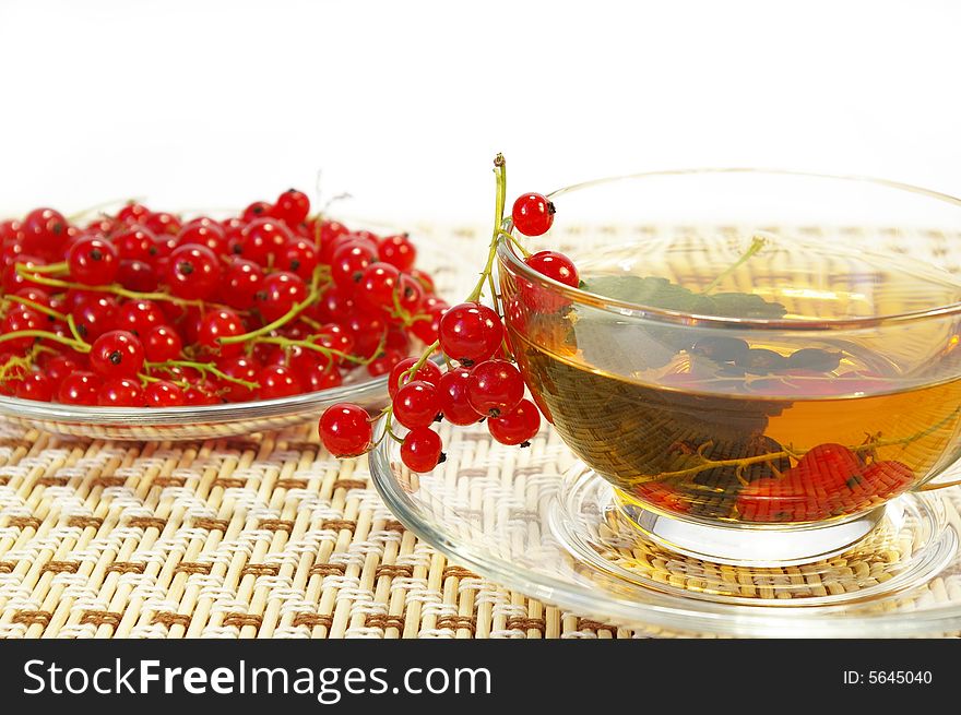 Red currant and herbal tea in a transparent cup. Red currant and herbal tea in a transparent cup