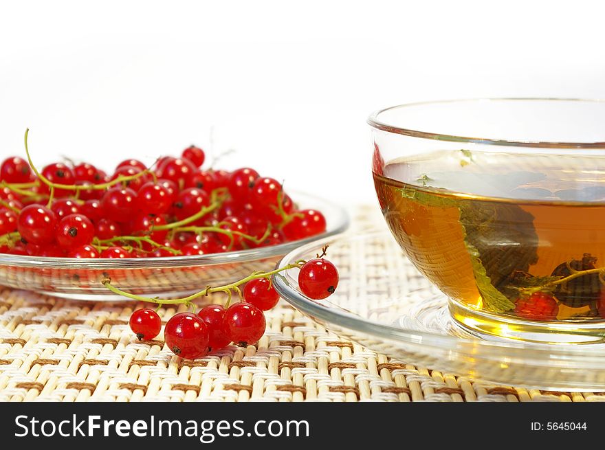 Red currant and herbal tea in a transparent cup