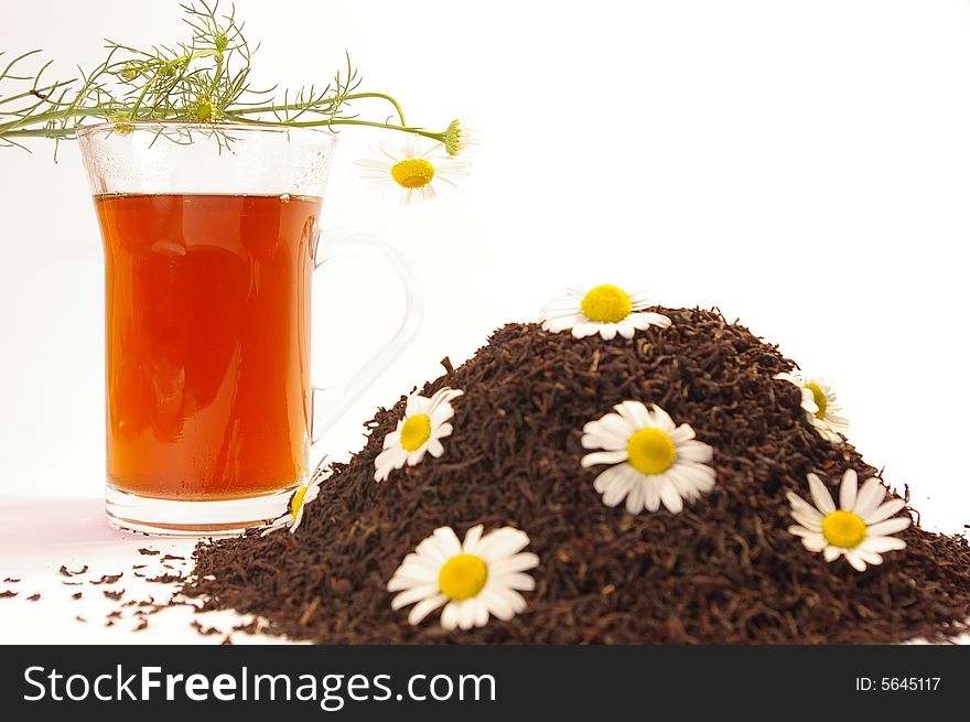 Herbal tea in a transparent cup and camomile. Herbal tea in a transparent cup and camomile