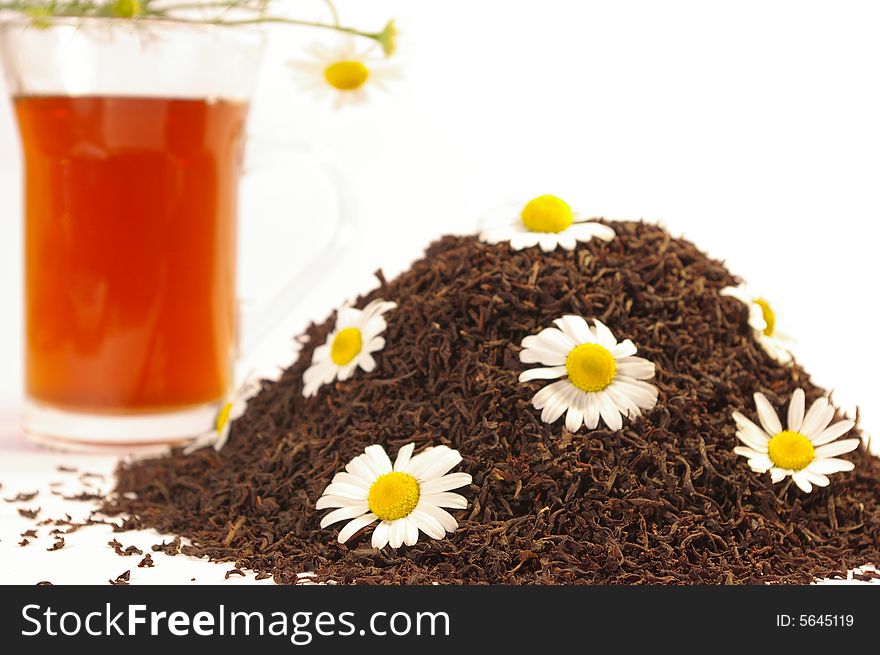 Black tea in a transparent cup and camomile. Black tea in a transparent cup and camomile