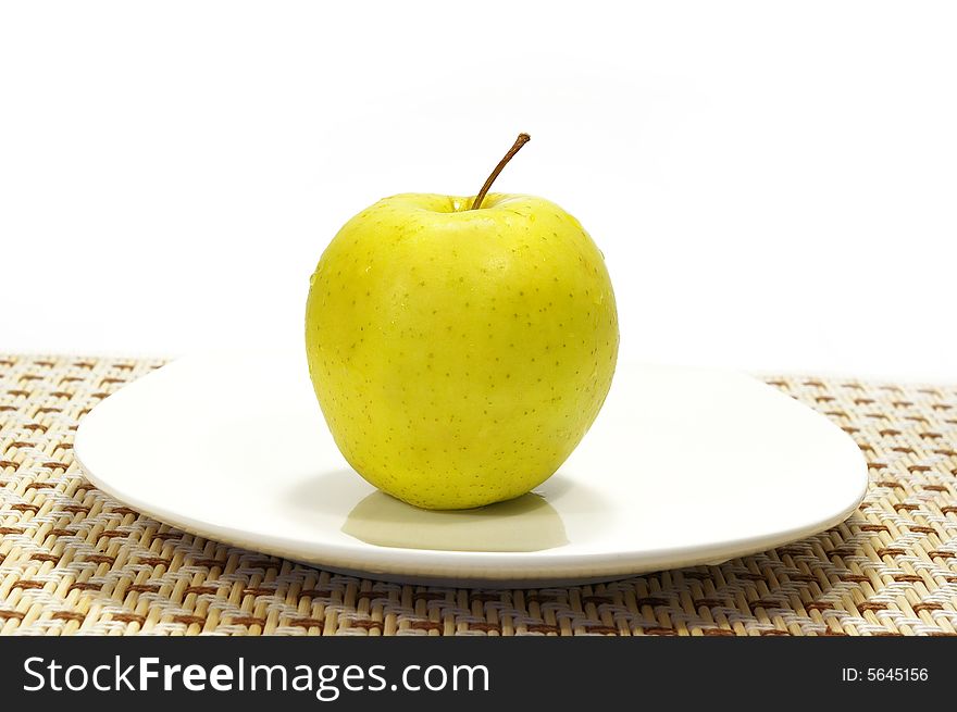 Apple on the white plate isolated