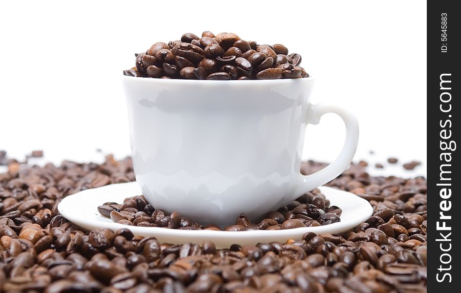 The cup full of coffee beans isolated at the white background
