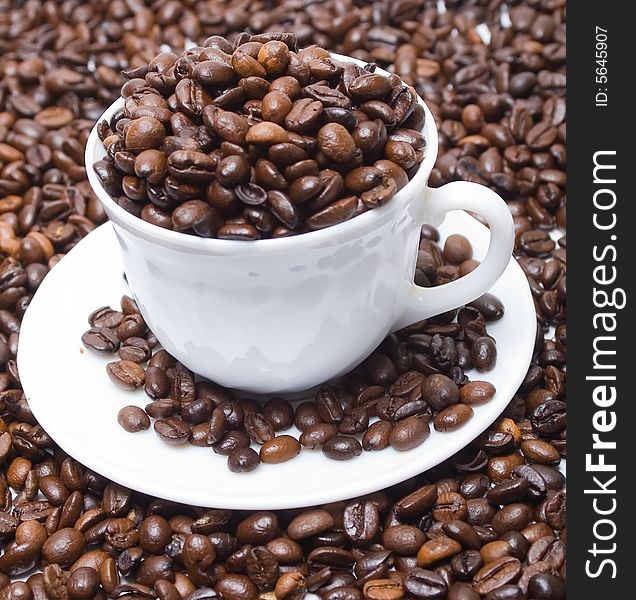 The cup full of coffee beans isolated at the white background