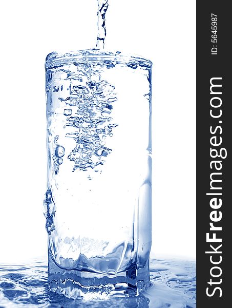 Big long drop of cold water poured into full glass (isolated on white background). Big long drop of cold water poured into full glass (isolated on white background)