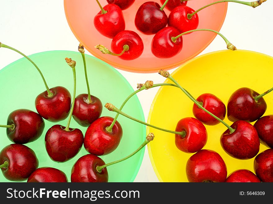Ripe cherries in colored bowls. Ripe cherries in colored bowls