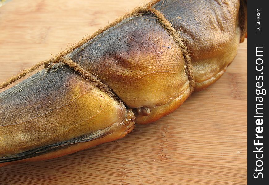 A hot smoked fish on the wooden board