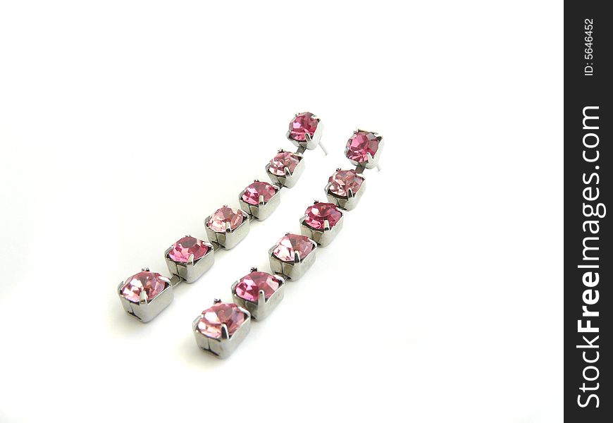 A pair of earrings with pink decorative stones isolated on white