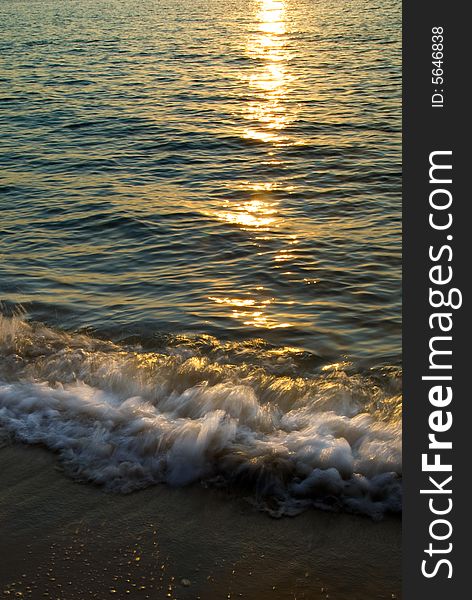 Dawn at the beach with sun reflected in the sea