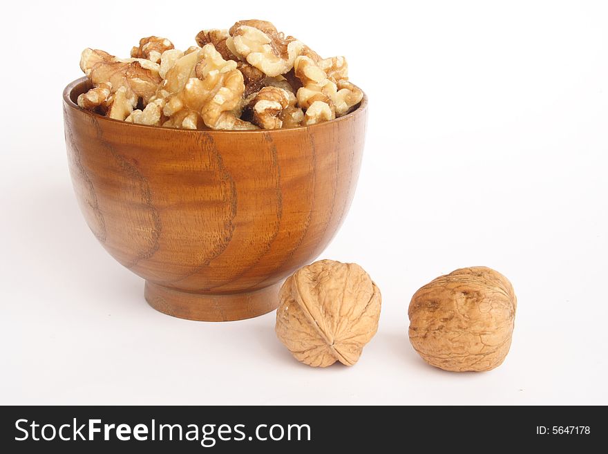 Bowl of peeled nuts and two more in white background