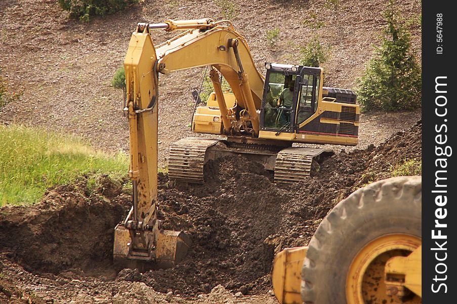 Excavator digging at job site in soft dirt. Excavator digging at job site in soft dirt.