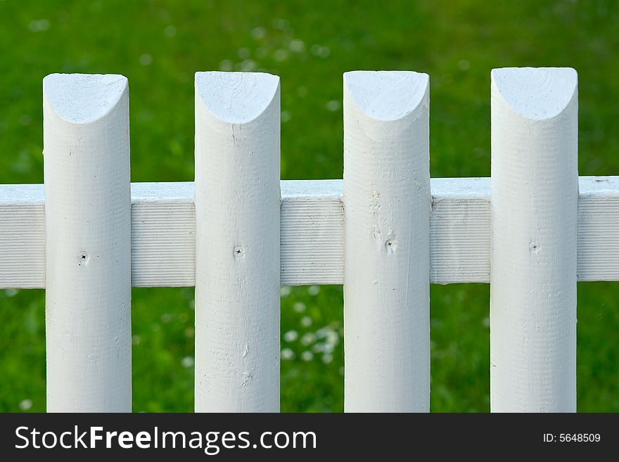 White picket fence over green grass