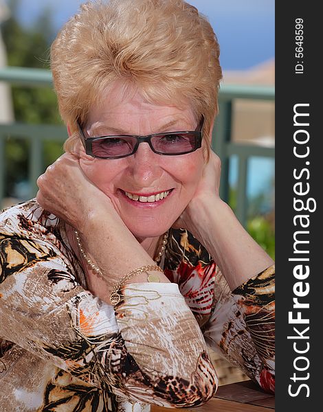 Beautiful smiling senior woman on a balcony. Beautiful smiling senior woman on a balcony