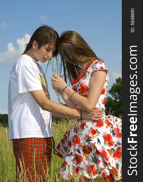 The teenagers walking across the green field. The teenagers walking across the green field.