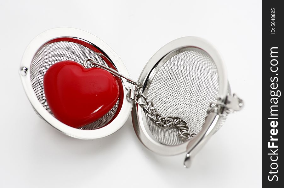 A close up view of a red heart in an open locket or pendant, isolated on a white background. A close up view of a red heart in an open locket or pendant, isolated on a white background.