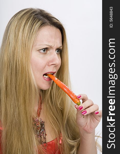 Long hair blonde woman with strong pepper in her mouth. Long hair blonde woman with strong pepper in her mouth