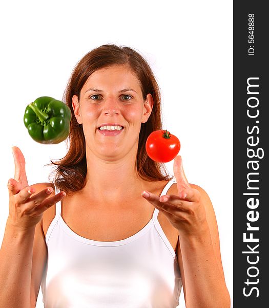 A young happy woman tosses up vegetable. Can be used as a cooking / diet shot. A young happy woman tosses up vegetable. Can be used as a cooking / diet shot.