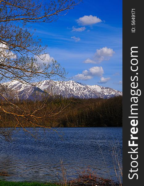 Mountain Lake in  spring with azure sky and some delicate clouds