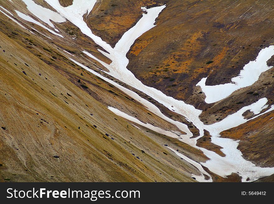 Snow between rocky slopes in late spring. Snow between rocky slopes in late spring