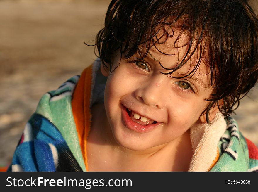 A kid at the beach smiles. A kid at the beach smiles.