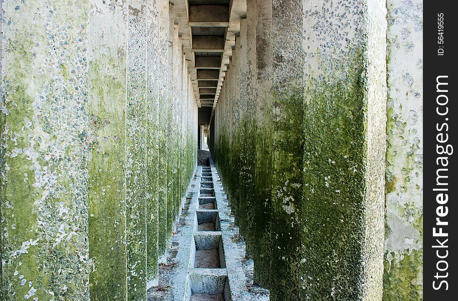 Corridor of old colored concrete pillars with perspective depth closeup