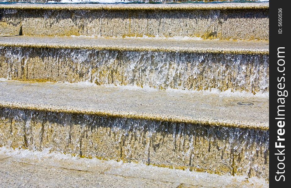 The image of a cascade fountain - steps on which runs water. The image of a cascade fountain - steps on which runs water.