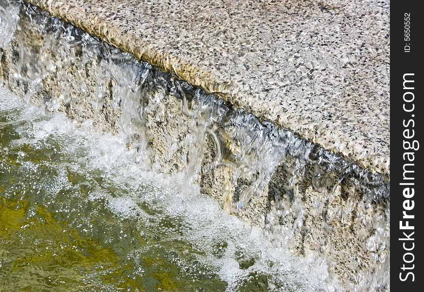 The image of a cascade fountain - steps on which runs water. The image of a cascade fountain - steps on which runs water.