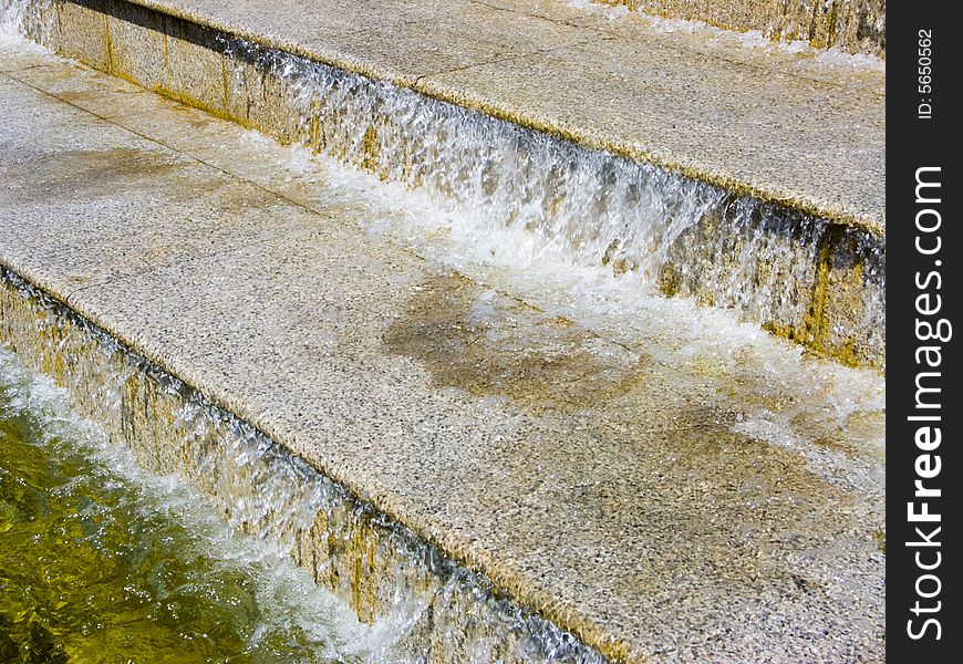 The image of a cascade fountain - steps on which runs water. The image of a cascade fountain - steps on which runs water.