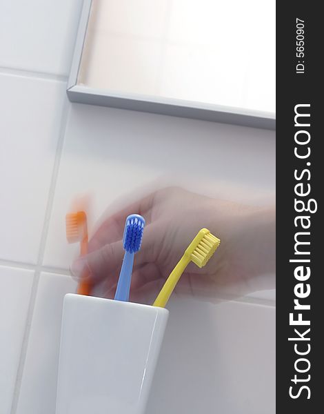 Family's toothbrush in white bathroom