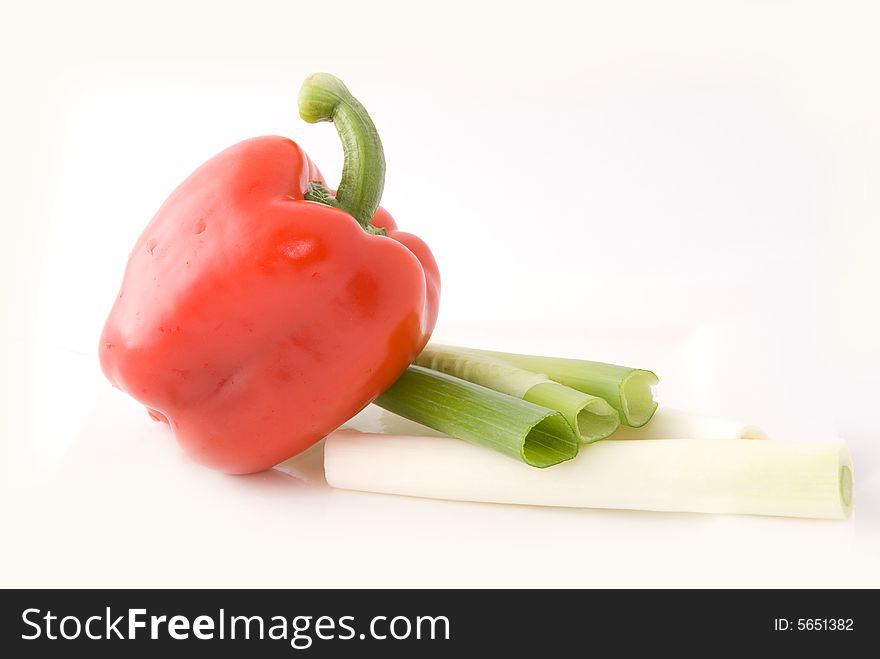 Capsicums and spring onion in lovely colors on white background, shot in studio. Capsicums and spring onion in lovely colors on white background, shot in studio