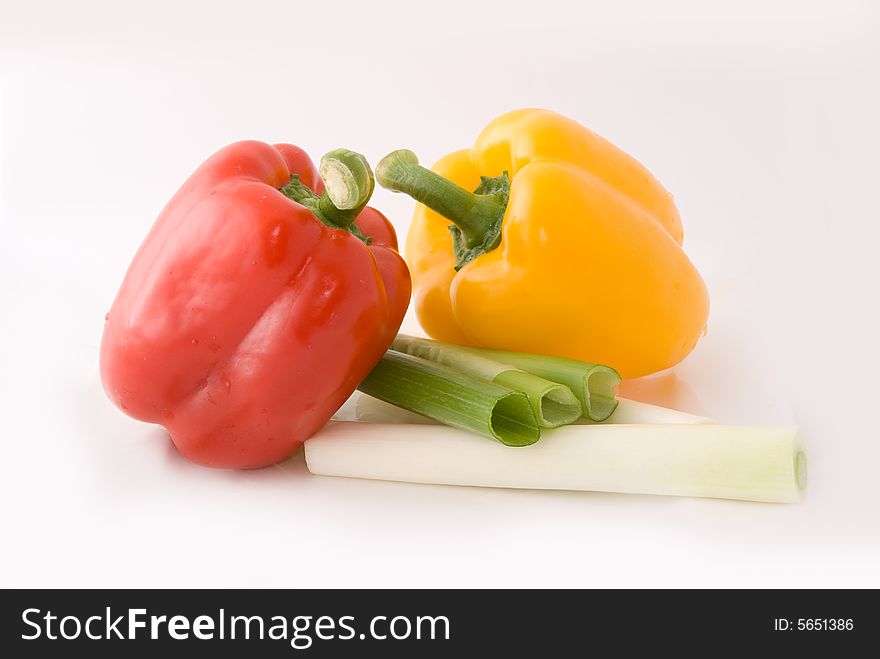 Capsicums and spring onion in lovely colors on white background, shot in studio. Capsicums and spring onion in lovely colors on white background, shot in studio