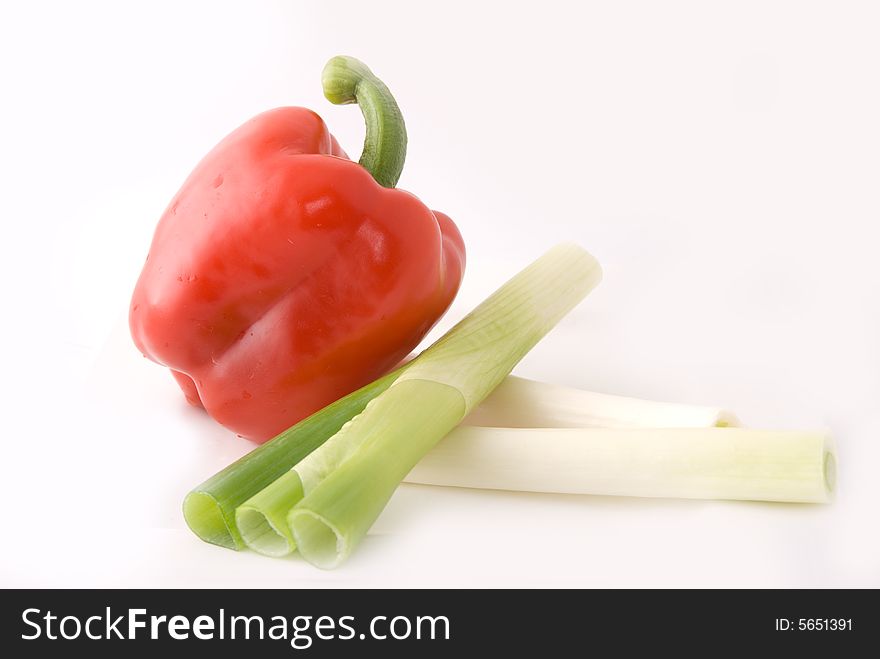 Capsicums and spring onion in lovely colors on white background, shot in studio. Capsicums and spring onion in lovely colors on white background, shot in studio