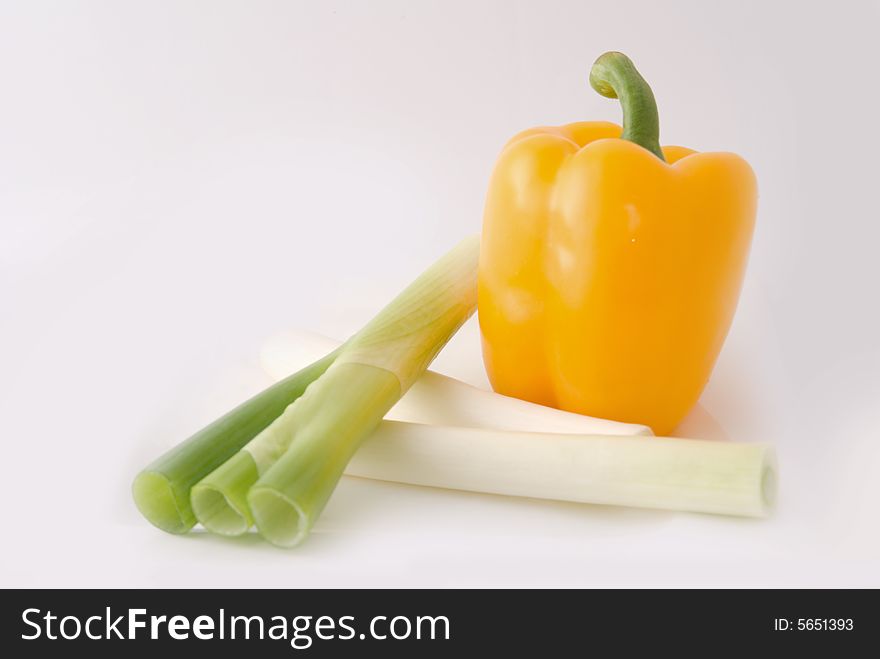 Capsicums and spring onion in lovely colors on white background, shot in studio. Capsicums and spring onion in lovely colors on white background, shot in studio