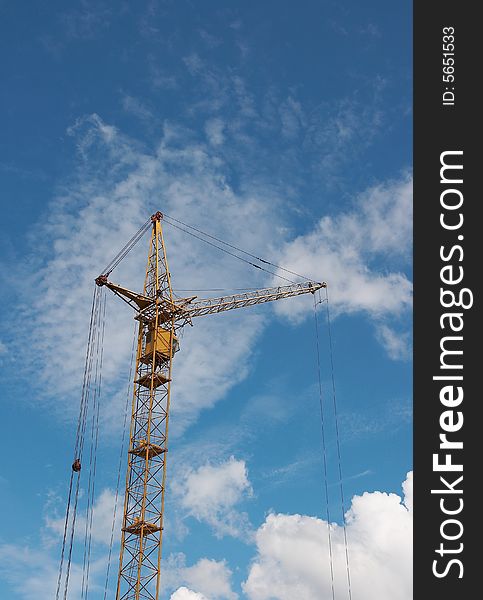 Lifting construction crane at blue sky - vertical. Lifting construction crane at blue sky - vertical