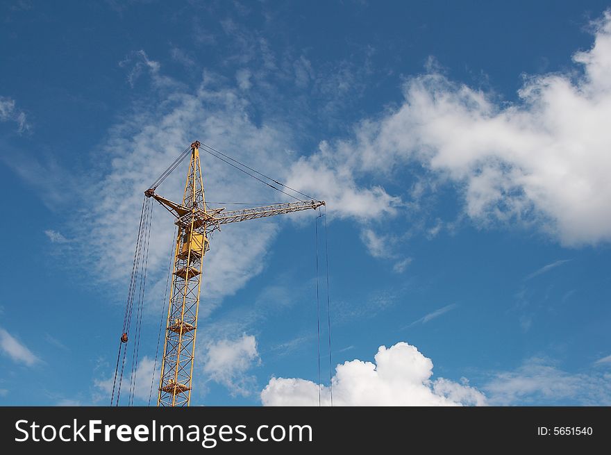 Lifting construction crane at blue sky - vertical. Lifting construction crane at blue sky - vertical