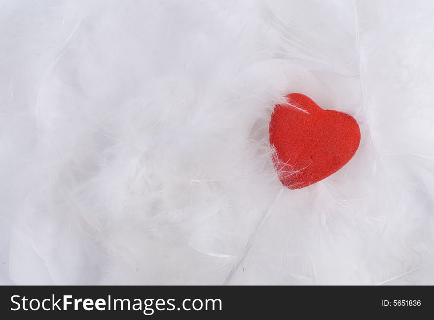 White feathers of birds at white background with heart. White feathers of birds at white background with heart