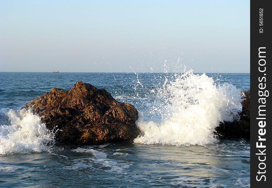 Wave crashing over rocks at the seaside. Wave crashing over rocks at the seaside