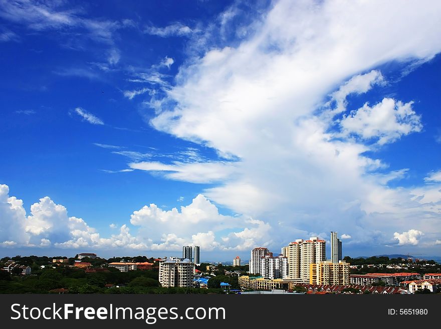 Cityscape over cloudy blue skies on sunny day. Cityscape over cloudy blue skies on sunny day.