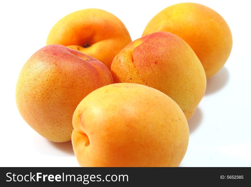 Five apricots isolated over white