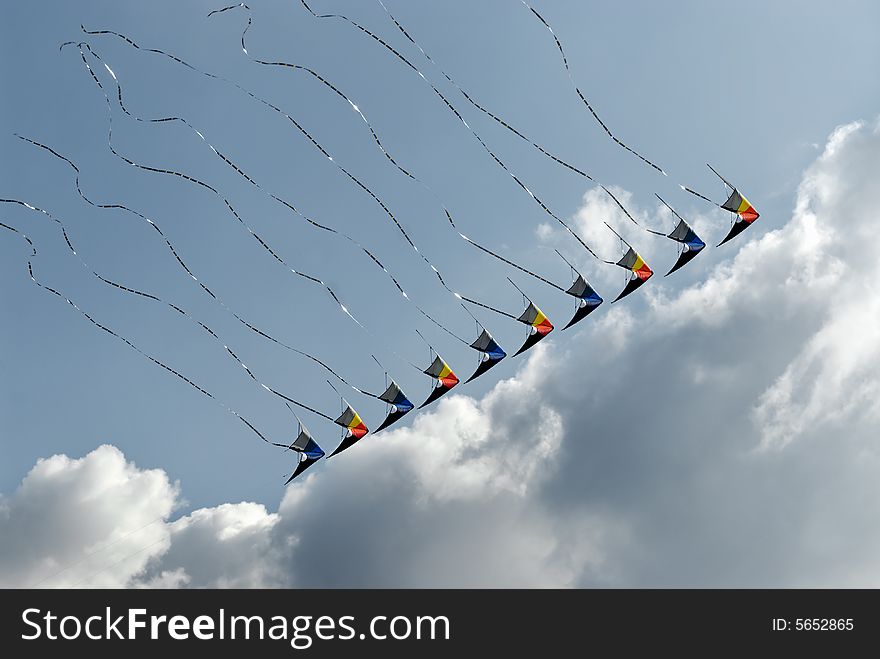 Lined up colorful kites in the sky with clouds. Lined up colorful kites in the sky with clouds