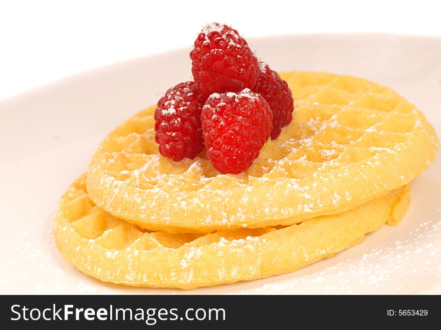 Freshly made waffles with raspberries and powdered sugar. Freshly made waffles with raspberries and powdered sugar